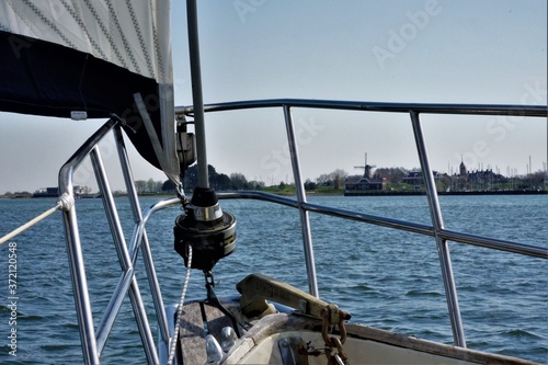 Beautiful view of Willemstad with windmill from the tip of a sailing yacht with the fence and jib in the foreground