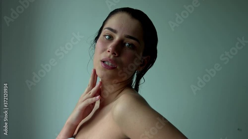 A young alluring woman looks defiantly at the camera. Tempts the beholder. Sexy brunette lover. Portrait of the mistress - head and shoulders.