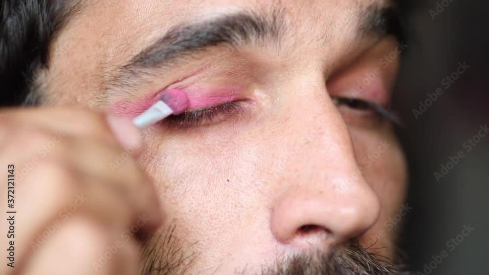 Guy putting on makeup, pink eyeshadow, LGBTQ Guy putting on makeup, pink eyeshadow, LGBTQ