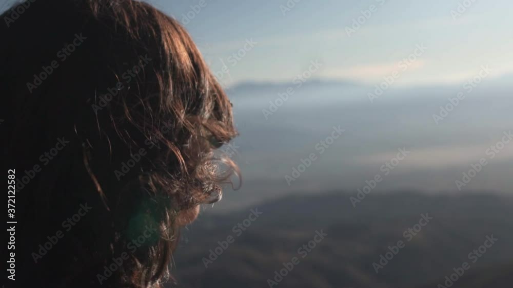 Woman on a mountain top at sunset Woman on a mountain top at sunset