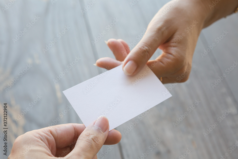 Obraz premium Hand holding Business card on a wood background