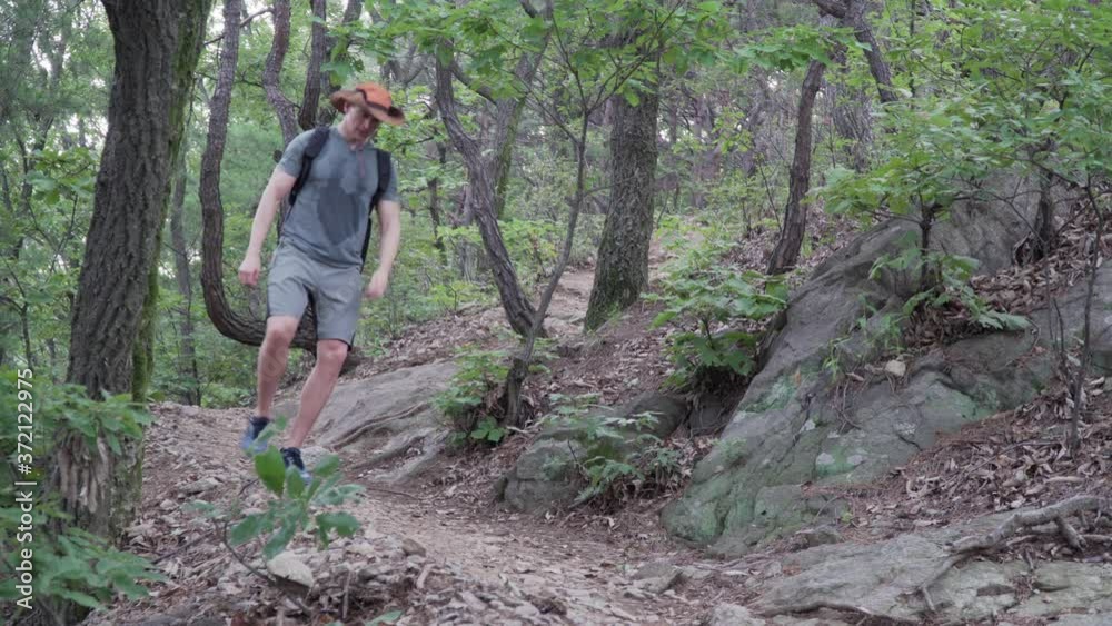 Male Hiker climbs down A Rocky Mountain With Narrow Path - Medium Shot, hiking concept Male Hiker climbs down A Rocky Mountain With Narrow Path - Medium Shot, hiking concept