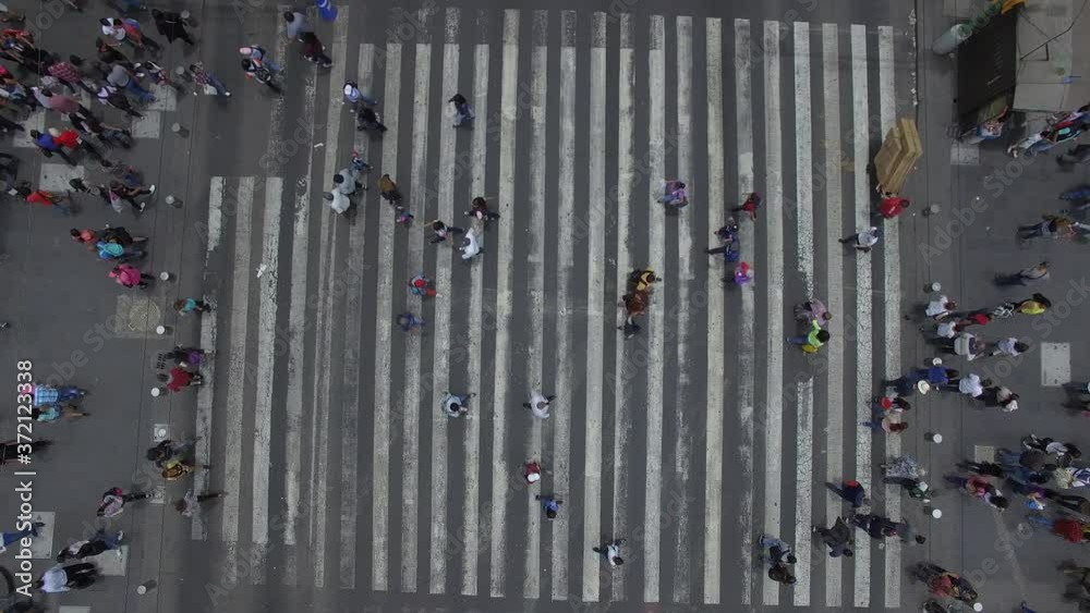 Vista aérea cenital para observar a una multitud pasar sobre el cruce peatonal más transitado de México.
