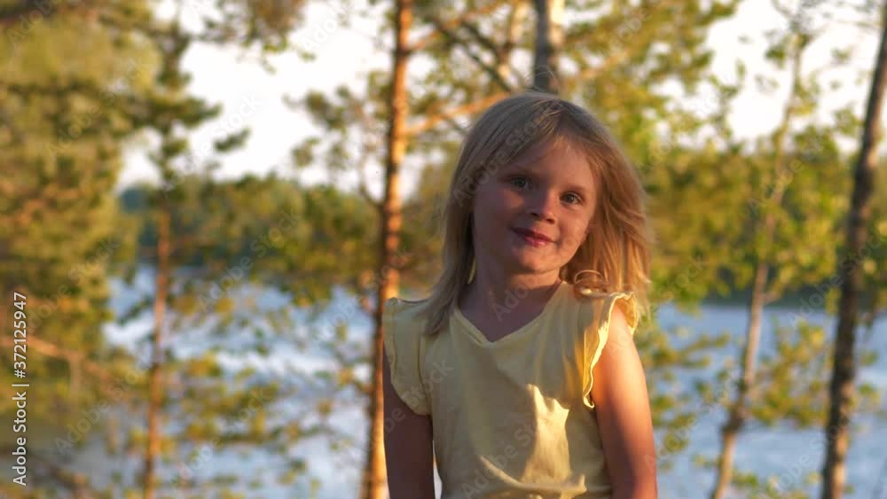 Smiling young girl in forest in sun, slow motion Smiling young girl in forest in sun, slow motion