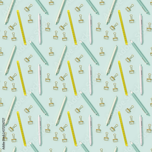 Creative seamless pattern with office supplies, white and green colored pens, yellow ruler and metal paper clips.