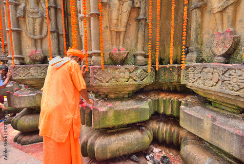 A priest praying to a stone carving of God at Kamakhya temple. photo