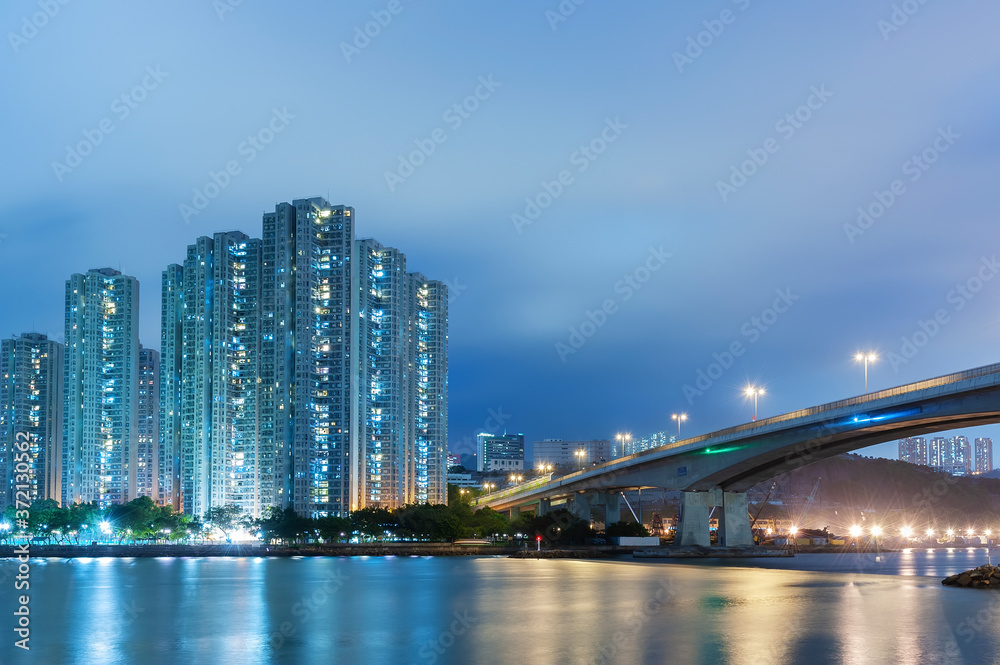 High rise residential building and bridge in Hong Kong city at night