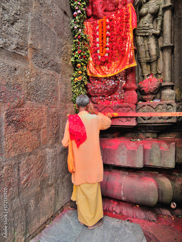 A priest worshiping a stone carving of God at Kamakhya temple. photo