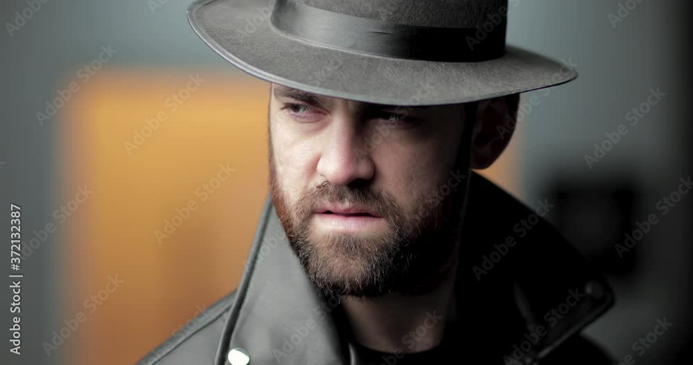 Mysterious man in hat glares behind him then turns and looks away, up close Mysterious man in hat glares behind him then turns and looks away, up close