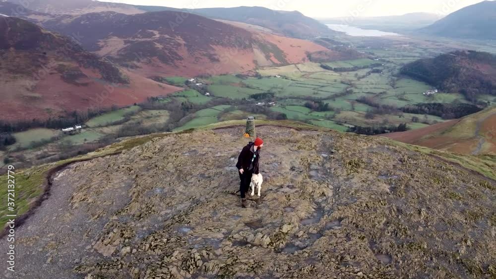 Walker enjoying the views from on top of mountain, aerial circle pan Walker enjoying the views from on top of mountain, aerial circle pan