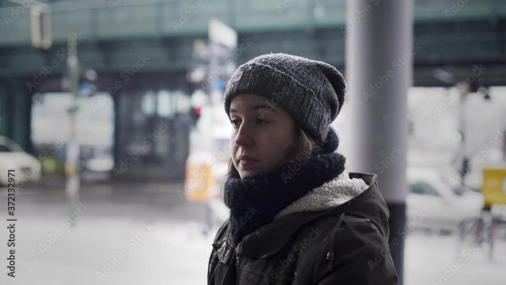 Young Caucasian woman wearing winter hat, scarf and jacket, staring into oblivion and in daze waiting for transportation, jet-lag concept, handheld close up slow motion profile Young Caucasian woman wearing winter hat, scarf and jacket, staring into oblivion and in daze waiting for transportation, jet-lag concept, handheld close up slow motion profile
