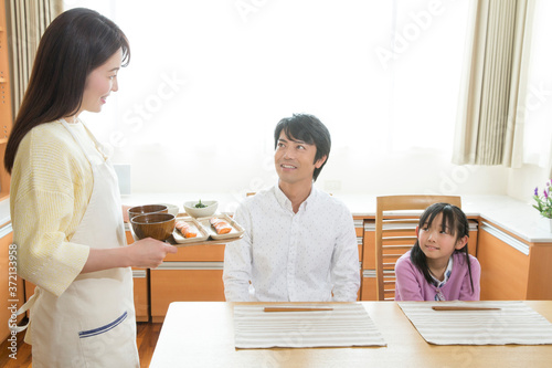 家族に食事を運ぶ母親