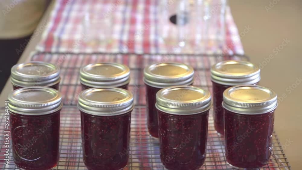 Man Sets New Jar of Fresh Raspberry Jam Next to Others Man Sets New Jar of Fresh Raspberry Jam Next to Others