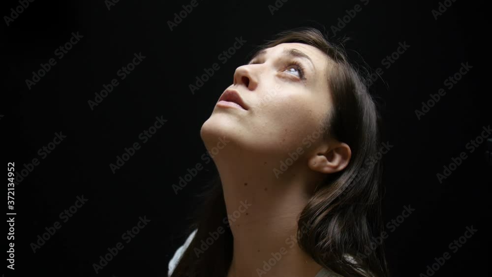Woman looks up at light coming from above. Woman looks up at light coming from above.
