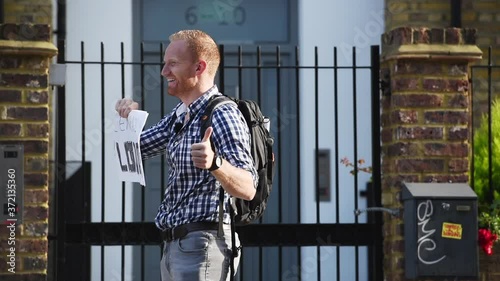 Good looking hitchhiker with backpack waving driver for a ride to central London photo