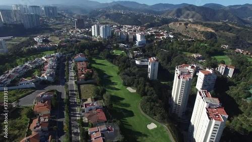 Detalle aéreo de la vivienda en el Lomas Country Club, en Naucalpan, el drone volando hacia el frente sobre las casas y campo de golf. photo