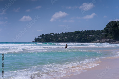 man walking on beach, big waves, beautiful lagoon. Excellent for advertise © Dima