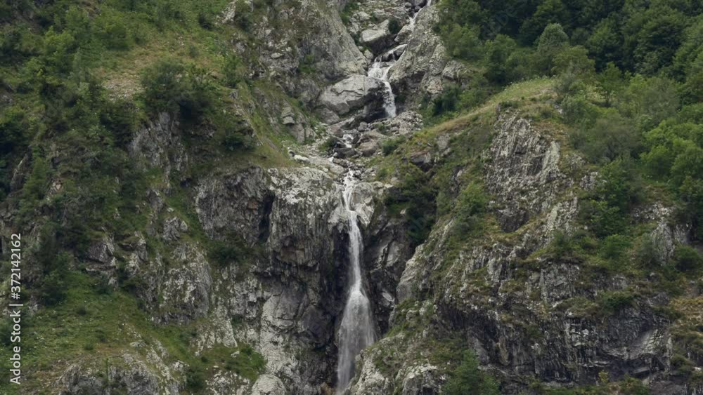 Detail shot of a waterfall that zooms out unveiling the Lauvitel lake in Venosc, Alps. 4K shot in ProRes Detail shot of a waterfall that zooms out unveiling the Lauvitel lake in Venosc, Alps. 4K shot in ProRes