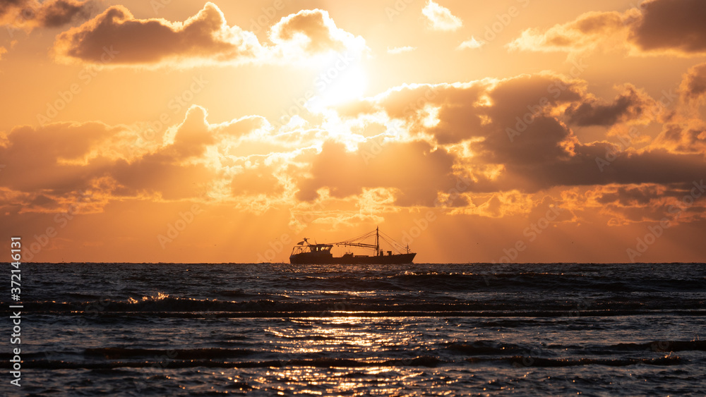 Trawler on the north see coast during beautiful golden sunset