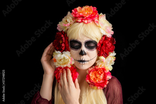Fototapeta Naklejka Na Ścianę i Meble -  Woman with sugar skull makeup and blond hair isolated on black background.