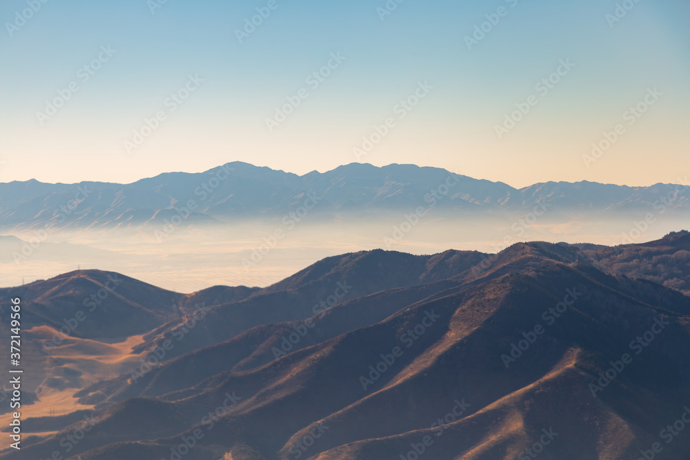 Aerial shot of stacked up mountains with fog and cloud
