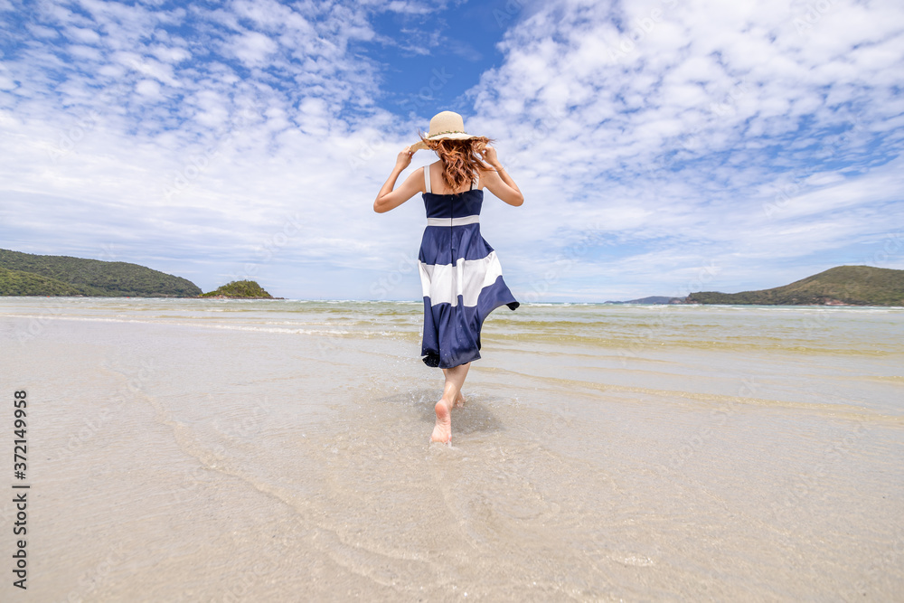 Woman barefoot walking on summer along wave of sea water and sand on the beach. Woman barefoot walking on summer along wave of sea water and sand on the beach.