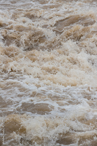 夏の豪雨で氾濫している川の様子