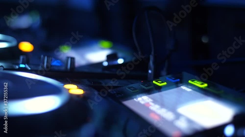 DJ hands inserting USB with music, in turntable deck at a nightclub photo