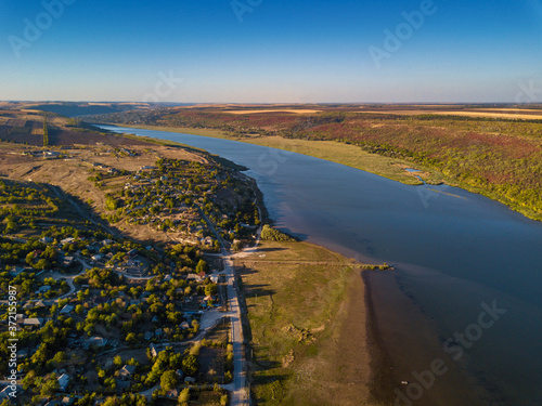 Flight over the river and small village in autumn. Moldova republic of. Molovata village. River Dniester.