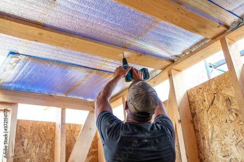 Bild auf Leinwand Work insulates the ceiling in the room.