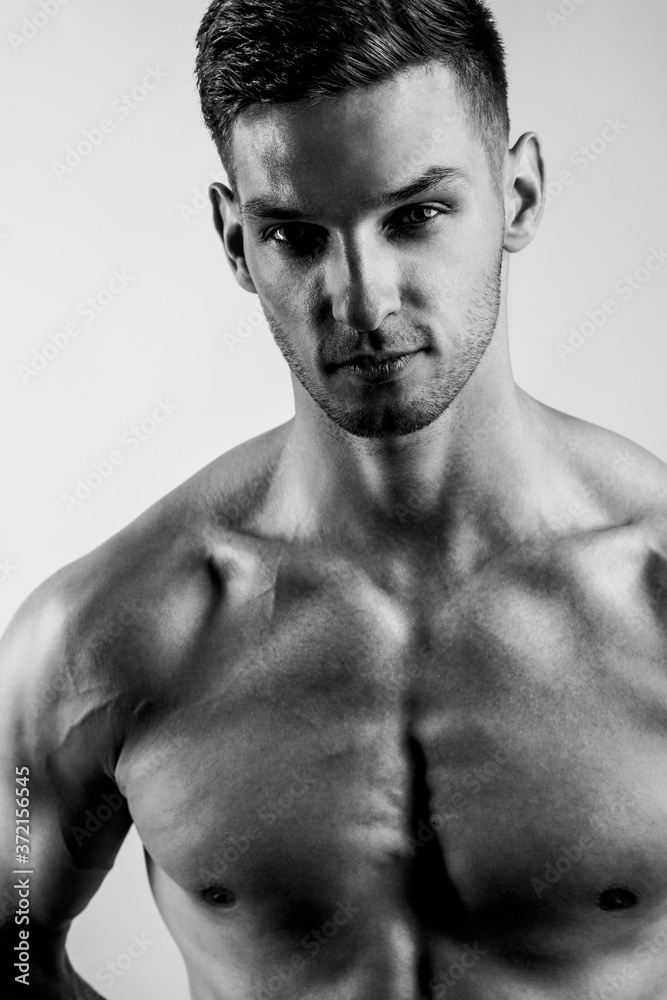Fototapeta premium Male beauty concept. Portrait of a shirtless handsome young man with stylish haircut posing over gray background. Close up. Studio shot
