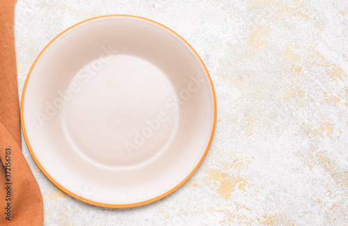 Clean plate with napkin on white background