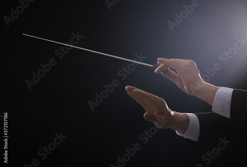 Hands of male conductor on dark background