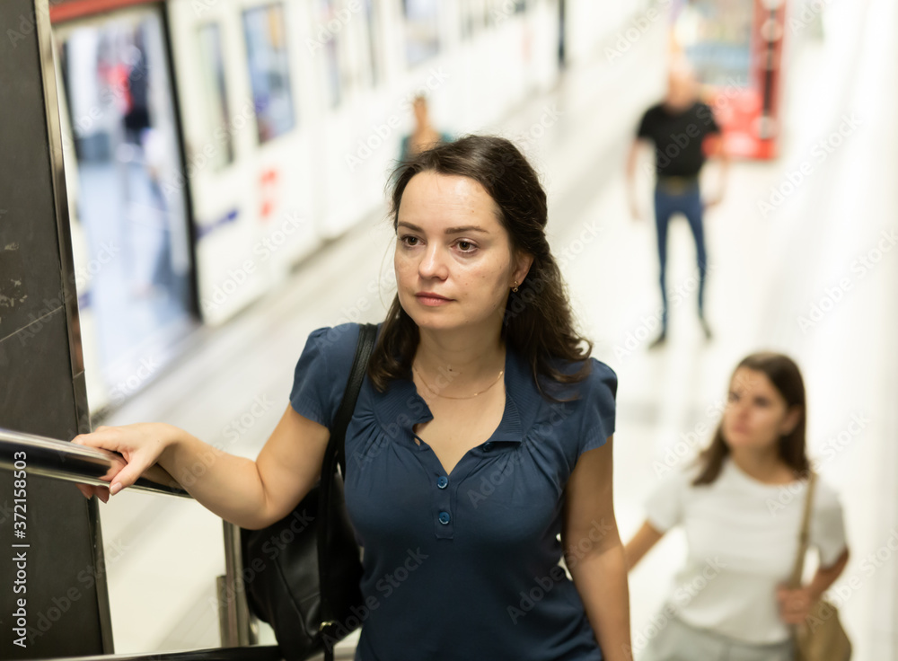 Pretty young woman climbs stairs at subway station. High quality photo