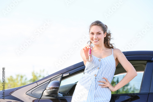 Happy woman with key near n...