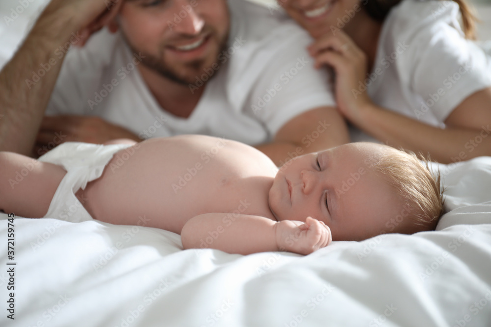 Happy couple with their newborn baby on bed, closeup Happy couple with their newborn baby on bed, closeup