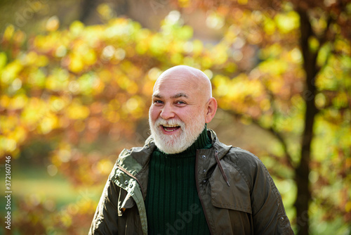 Portrait of a happy senior man outdoors, walking in a park. © Volodymyr