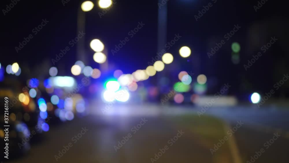 Blue police lights blinking on street, car accident, bokeh circles in background