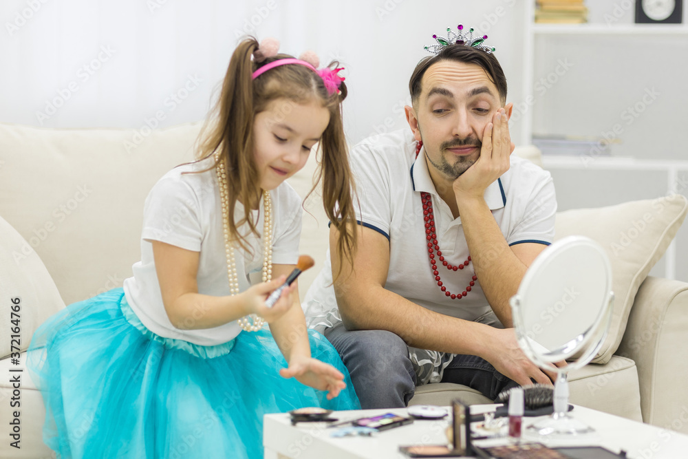 Fototapeta premium Photo of little girl applying makeup with her father.