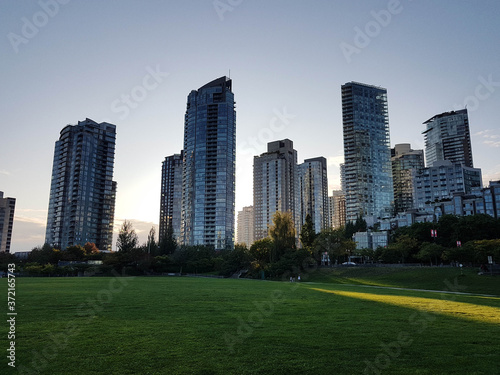 Park view in Vancouver with tall apartment buildings and clear sky.