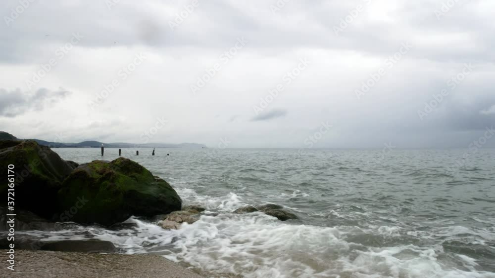 Powerful splashing force ocean tide waves breaking wild overcast coastal rocky shoreline Powerful splashing force ocean tide waves breaking wild overcast coastal rocky shoreline