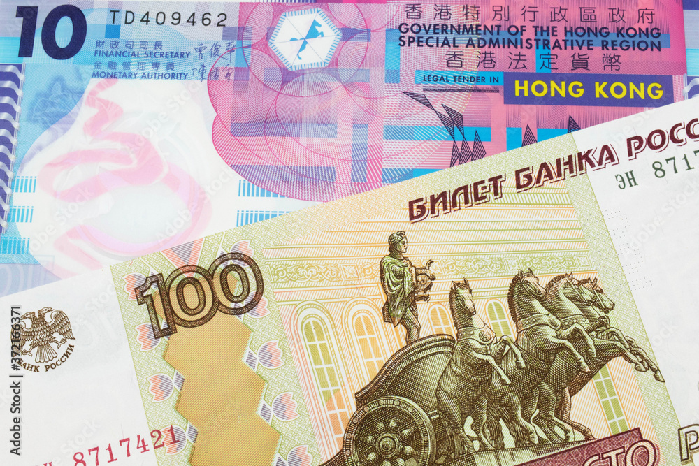 A macro image of a Russian one hundred ruble note paired up with a pink and purple, plastic ten dollar bill from Hong Kong.  Shot close up in macro.