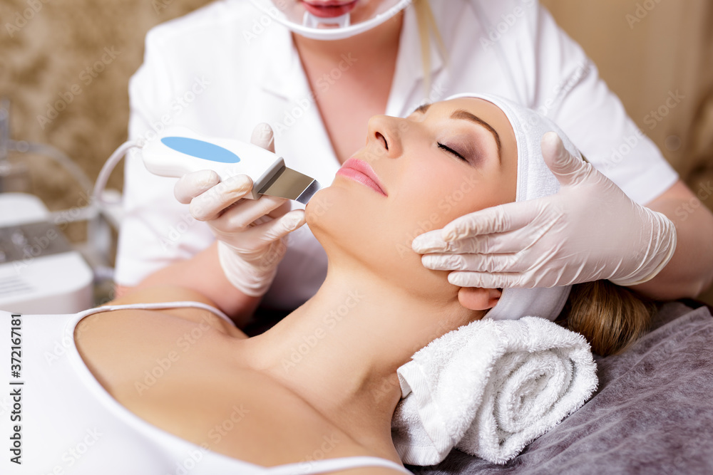 cosmetology and beauty concept - close up of beautiful woman receiving ultrasound cavitation facial peeling
