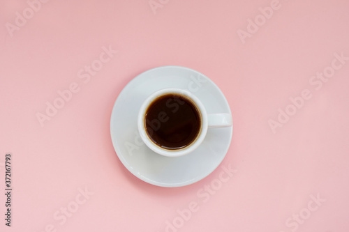 White cup of strong coffee on pink background Copy space