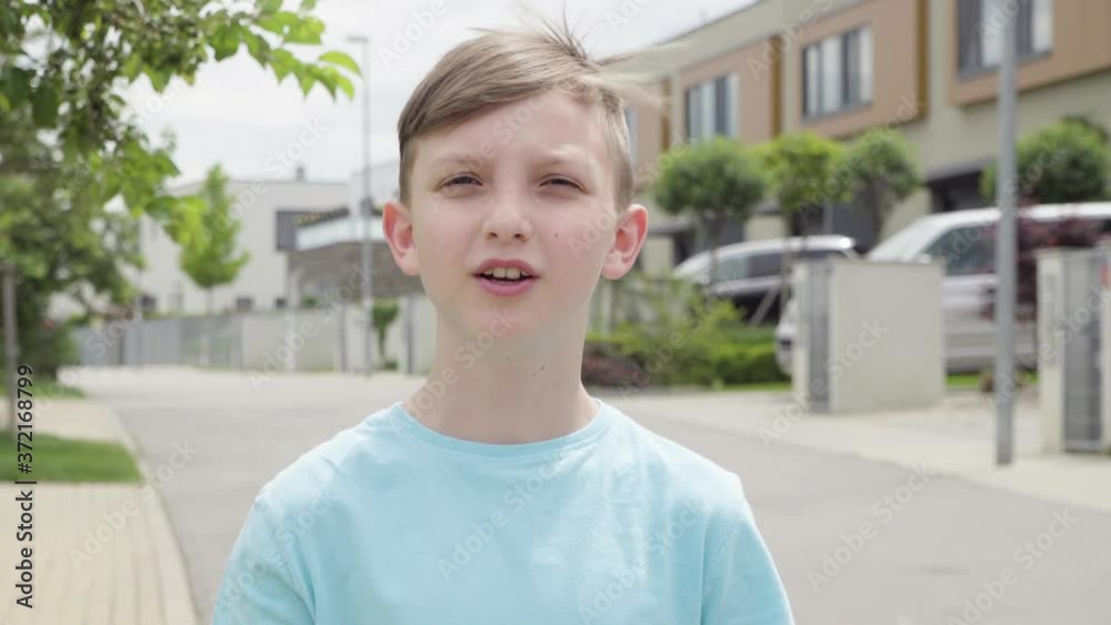 A young boy talks to the camera, then puts on a face mask and talks more in an empty suburban area - closeup A young boy talks to the camera, then puts on a face mask and talks more in an empty suburban area - closeup