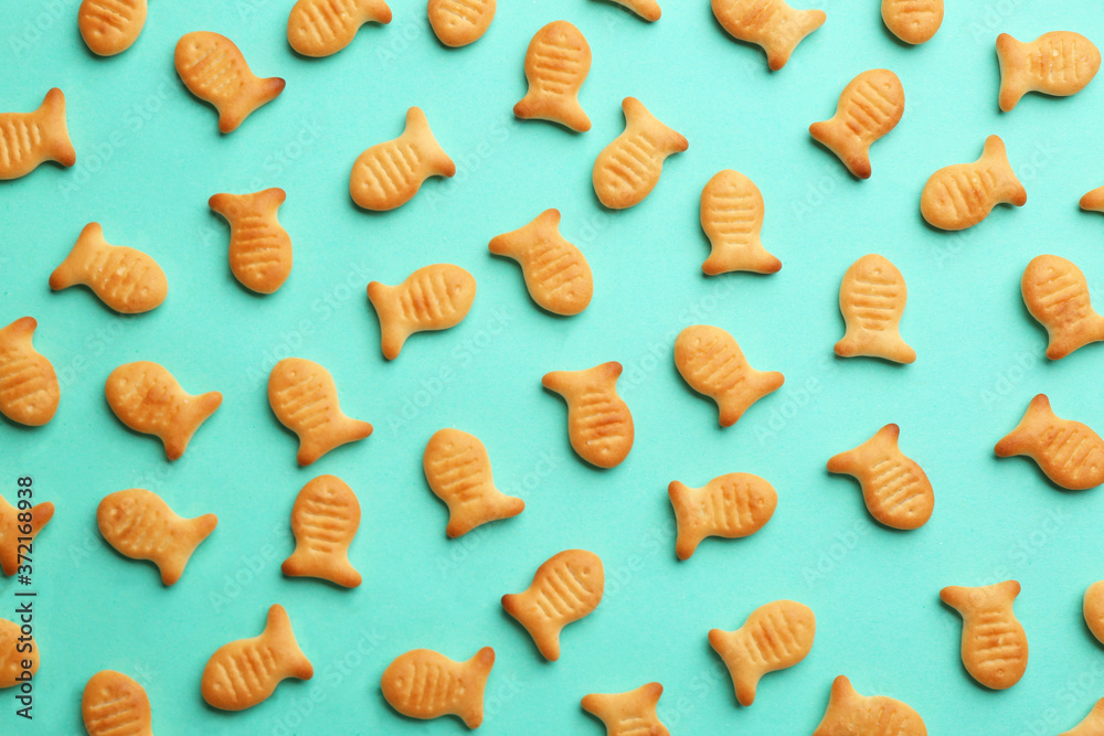 Delicious goldfish crackers on turquoise background, flat lay Delicious goldfish crackers on turquoise background, flat lay