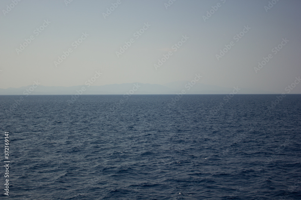 Greece. Rhodes island. Rest at the sea. Euro-trip. Sea water surface. Mountains in the background. Greece. Rhodes island. Rest at the sea. Euro-trip. Sea water surface. Mountains in the background.