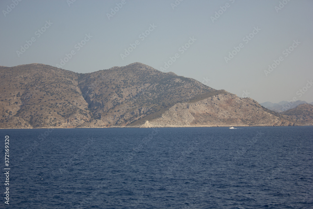 Greece. Rhodes island. Rest at the sea. Euro-trip. Sea water surface. Mountains in the background.