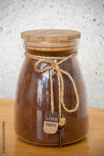 Ground coffee in glass jars on a wooden table.