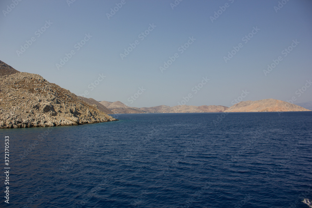 Greece. Rhodes island. Rest at the sea. Euro-trip. Sea water surface. Mountains in the background. Greece. Rhodes island. Rest at the sea. Euro-trip. Sea water surface. Mountains in the background.